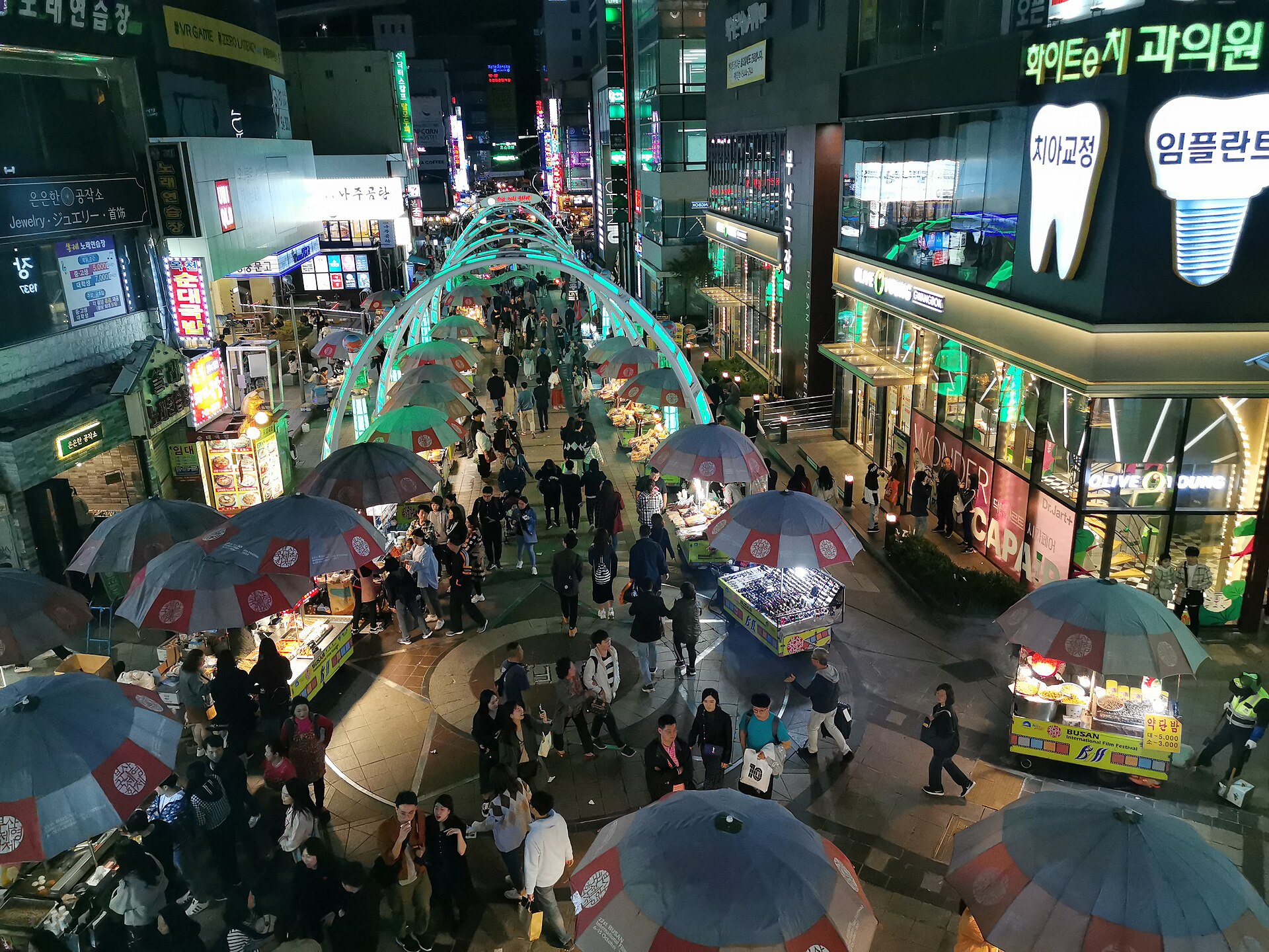 An illuminated shopping street with street stalls in the Nampo area of Busan